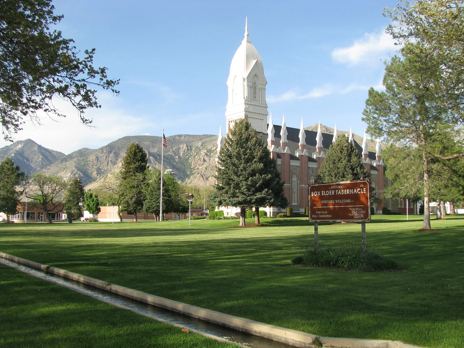 Historic Box Elder Tabernacle in Brigham City, Utah, with mountains in the background.