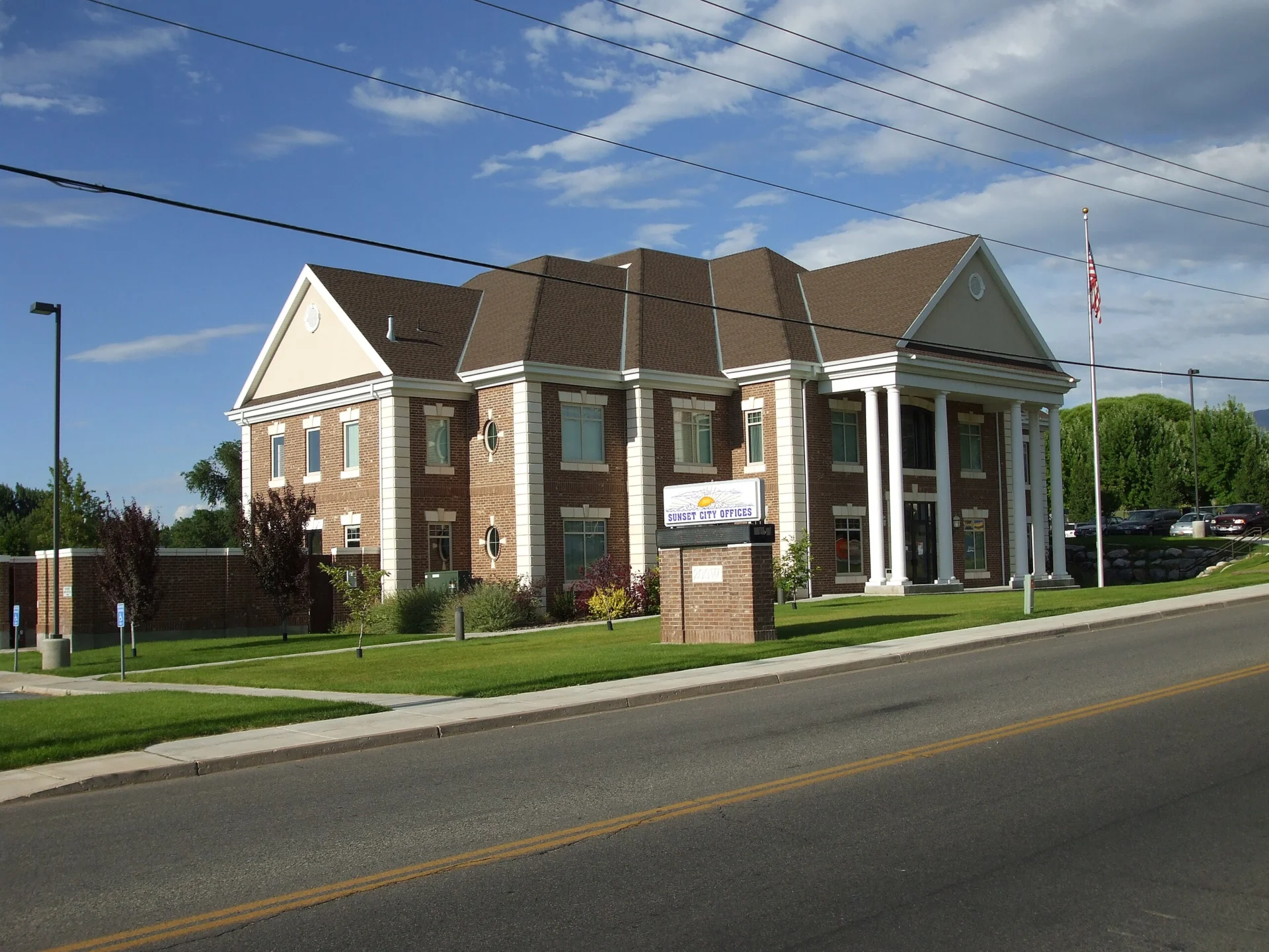 Sunset City Offices building with American flag and columns.