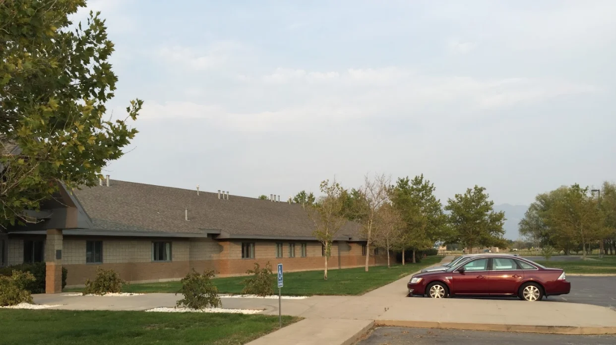 Building exterior with parked cars and trees